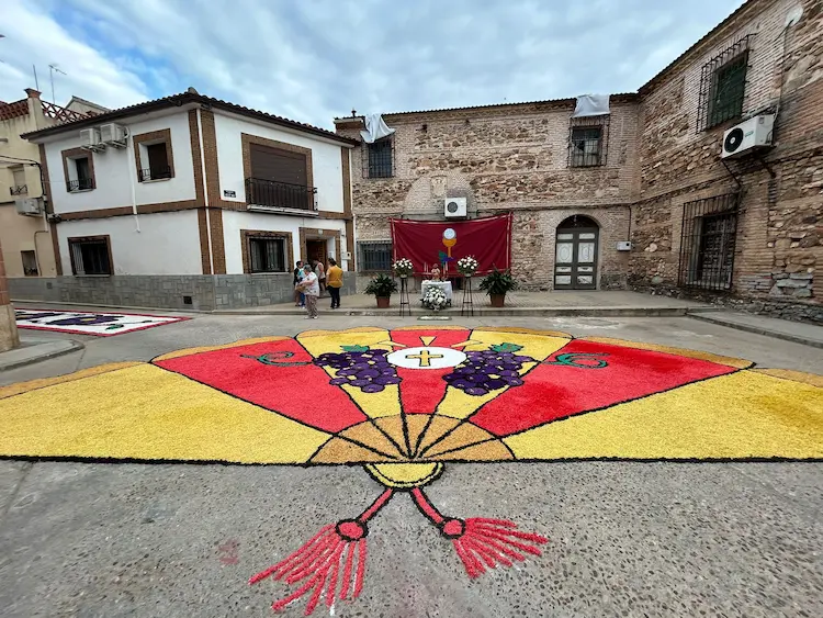 Alfombra en forma de abanico decorada con racimos de uvas y formas litúrgicas en Los Navalmorales durante el Corpus Christi 2025
