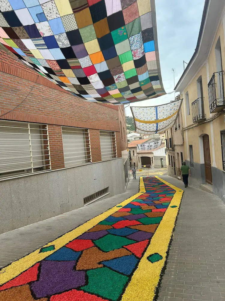 Otra alfombra multicolor de la calle feria en Los Navalmorales durante el Corpus Christi 2025