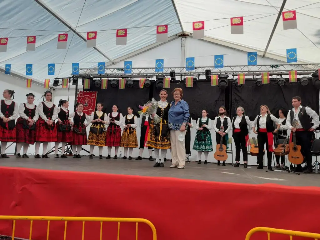 Actuación del grupo de coros y danzas Virgen de la Antigua en Los Navalmorales durante entrega de flores sobre el escenario