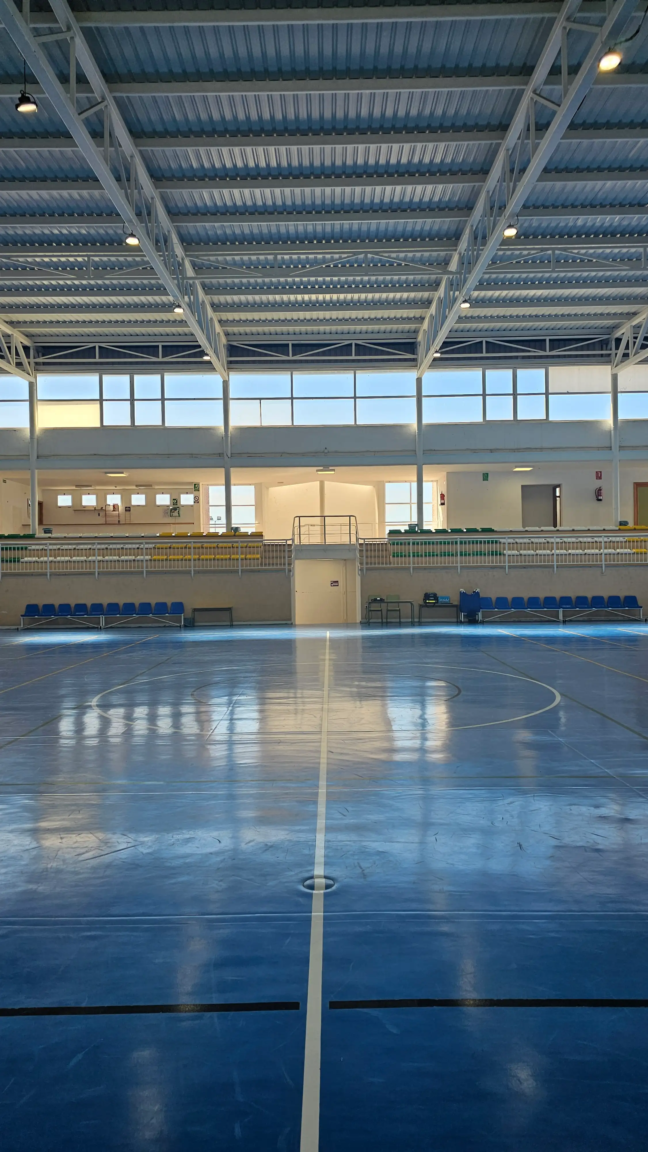 Vista frontal de la grada con asientos verdes y amarillos