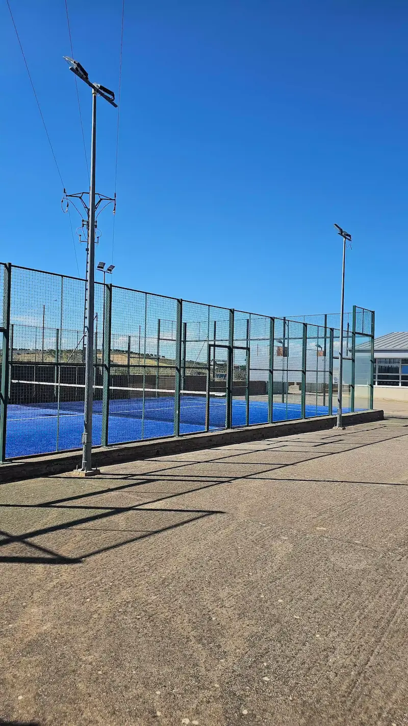 Exterior de la pista de pádel de Los Navalmorales con cerramiento perimetral y focos de iluminación