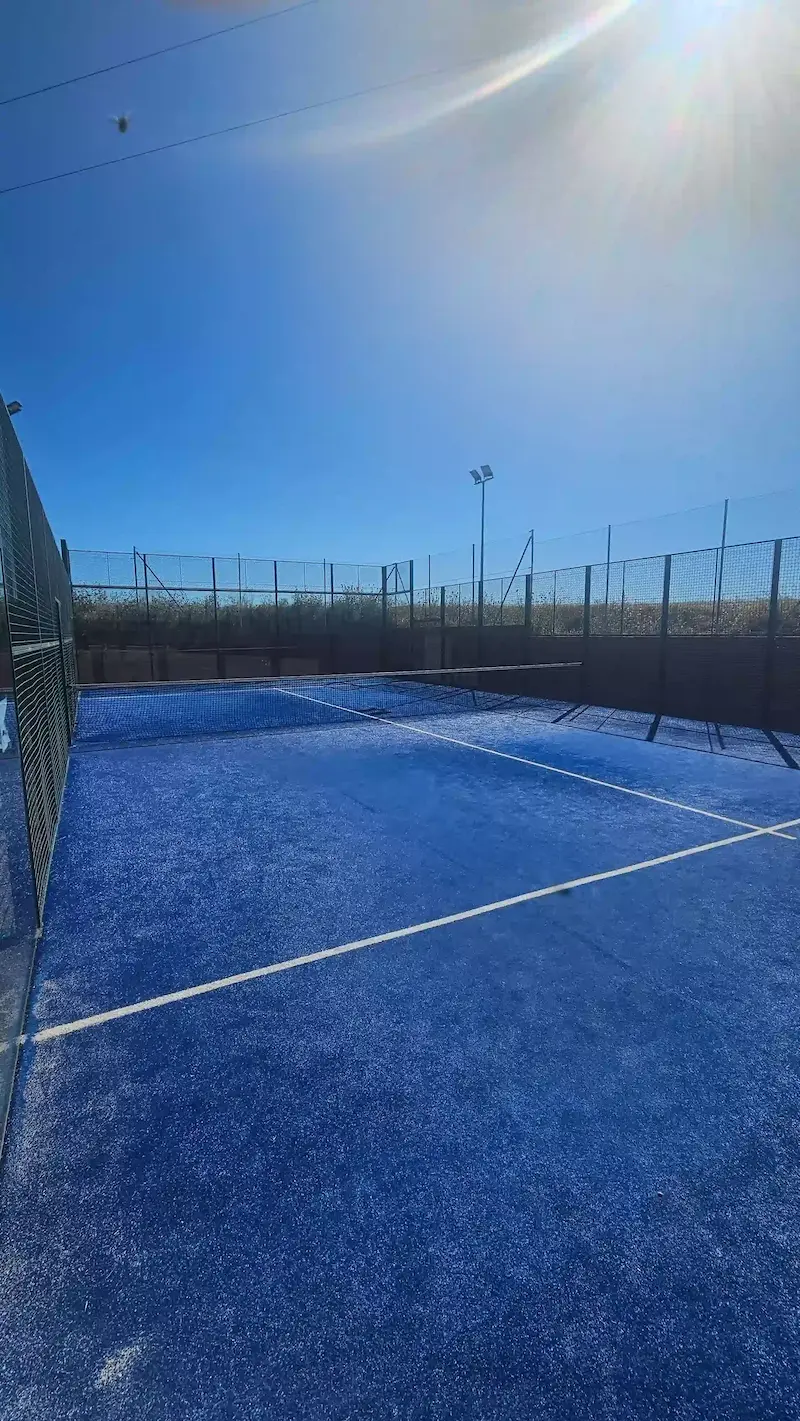 Pista de pádel municipal de Los Navalmorales iluminada por el sol, ideal para jugar al aire libre