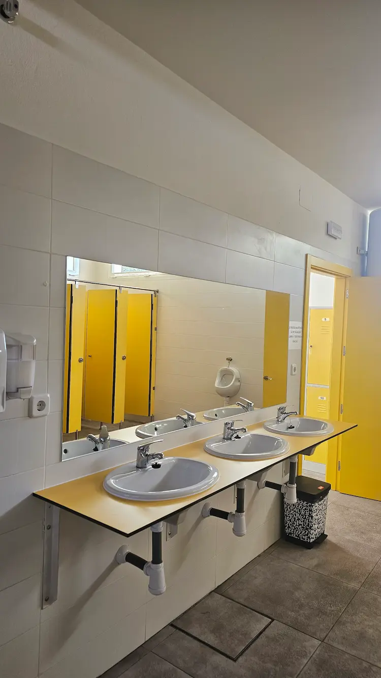 Vestuarios modernos con lavabos y aseos en la piscina municipal de Los Navalmorales, cómodos y limpios.