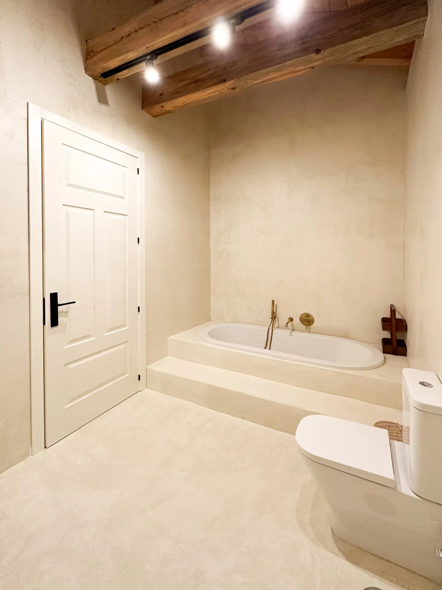 Baño completo con bañera encastrada y techo de madera