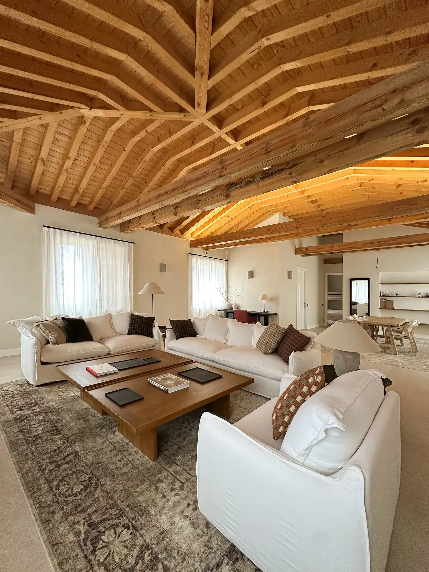 Salón principal con sofás, mesa y techo de madera