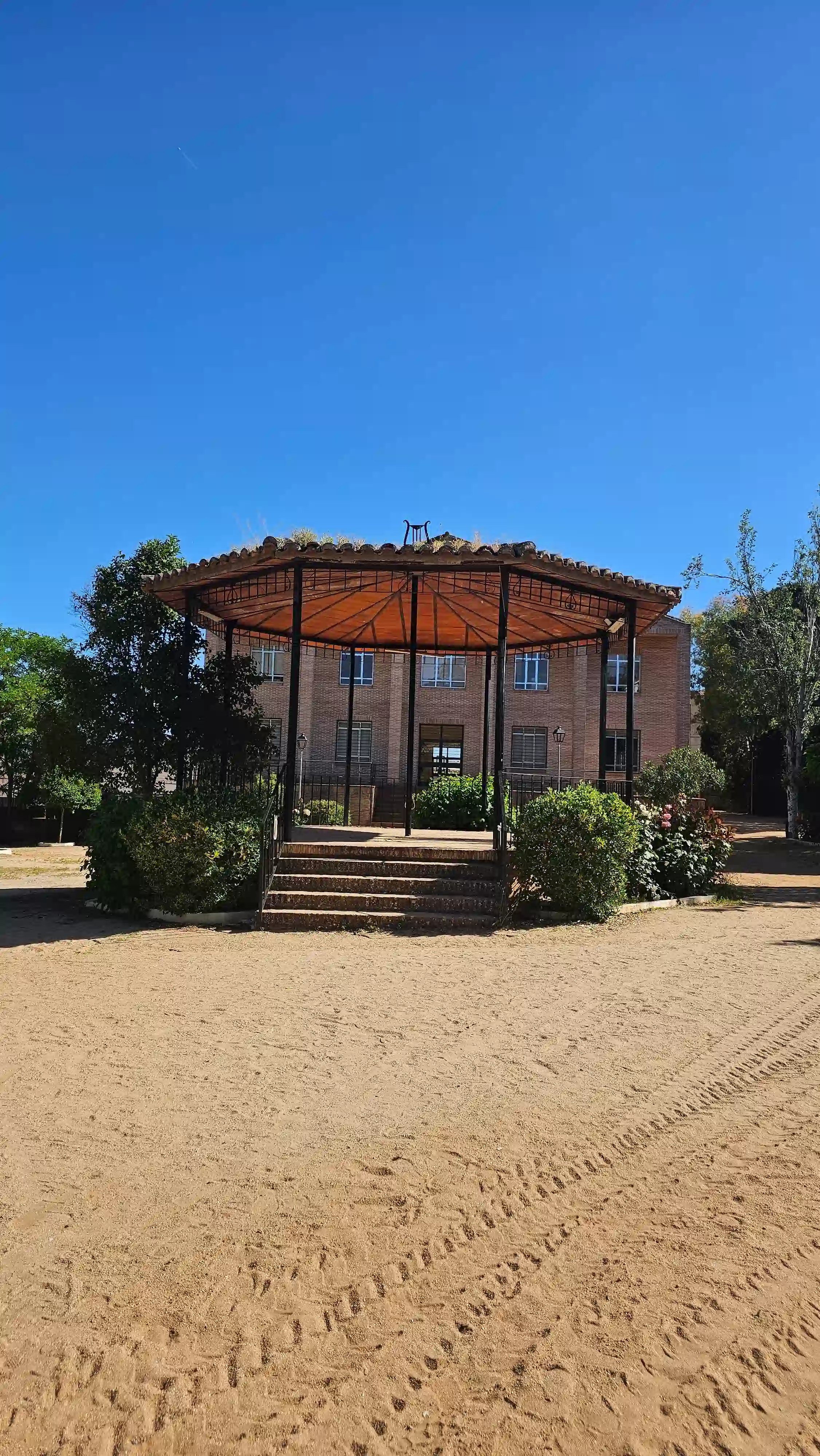 Templete de ladrillo en el parque de Los Navalmorales, rodeado de arena y vegetación